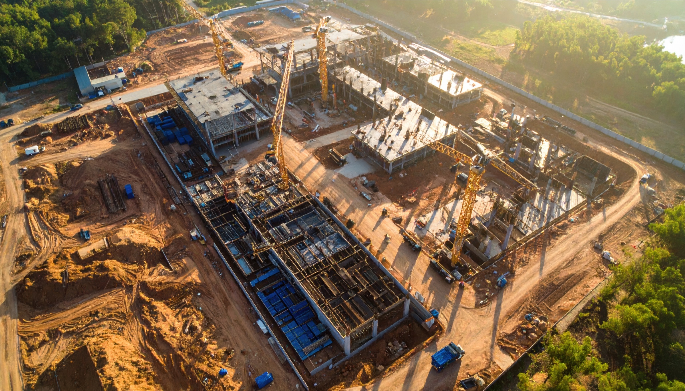 Aerial view of large construction site with multiple cranes